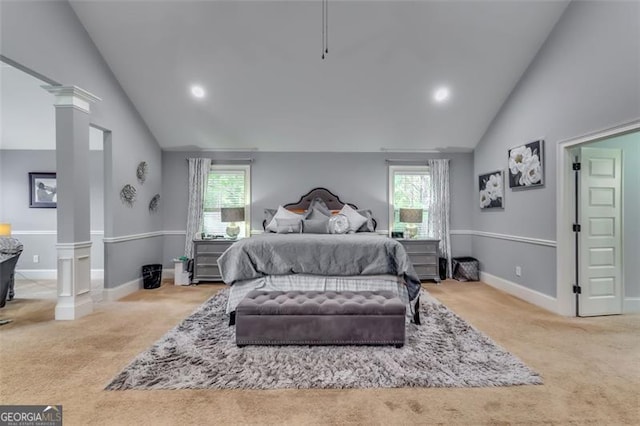 carpeted bedroom featuring decorative columns, multiple windows, and high vaulted ceiling