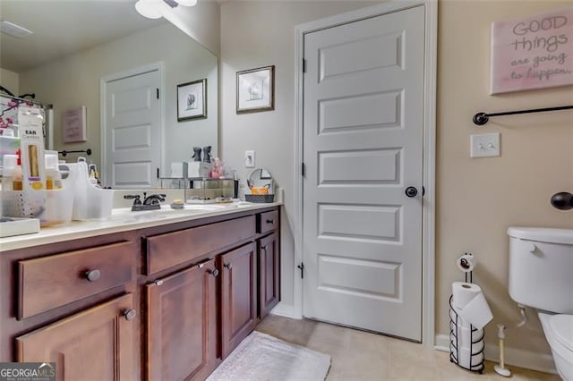 bathroom featuring tile patterned flooring, vanity, and toilet