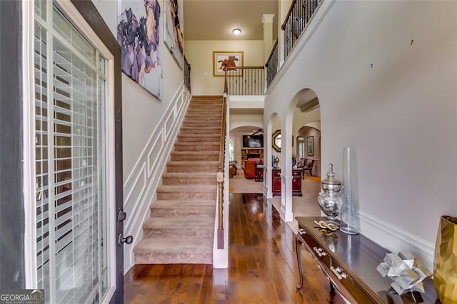 entrance foyer with a towering ceiling and dark wood-type flooring