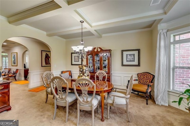 carpeted dining space with crown molding, beamed ceiling, coffered ceiling, and an inviting chandelier