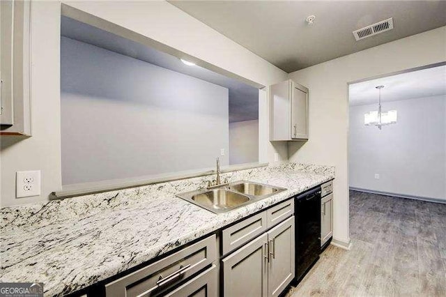 kitchen featuring sink, gray cabinets, light wood-type flooring, black dishwasher, and decorative light fixtures