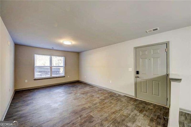 empty room with dark hardwood / wood-style flooring