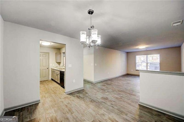 interior space with light hardwood / wood-style flooring, a notable chandelier, and sink