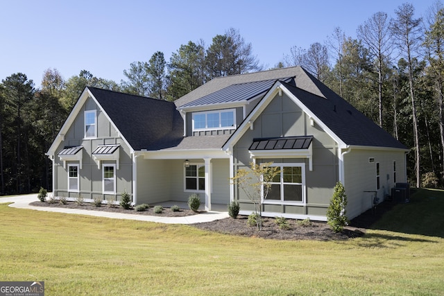 view of front of home with central AC unit and a front lawn