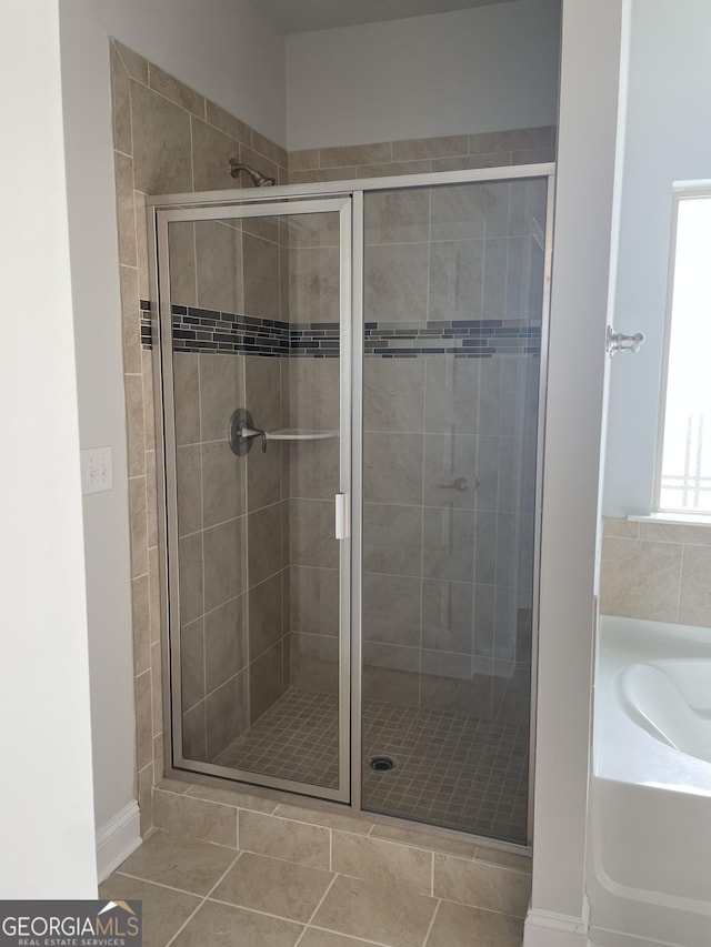 bathroom with tile patterned flooring and independent shower and bath