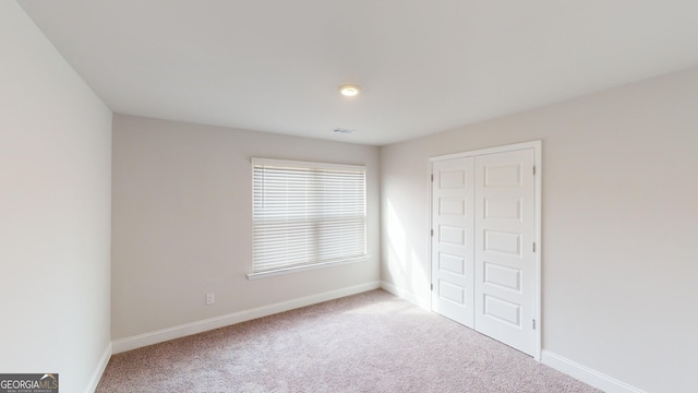 unfurnished bedroom with carpet and a closet