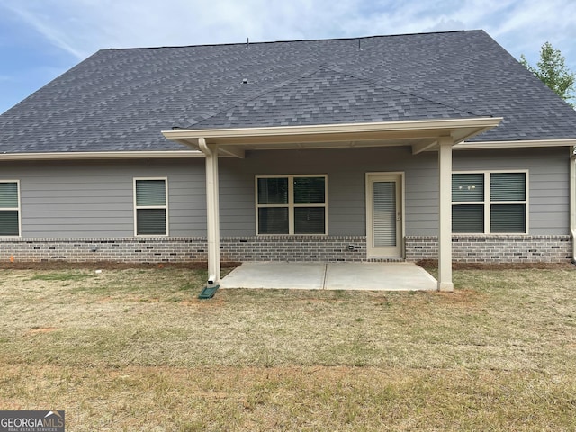 back of house with a patio and a lawn