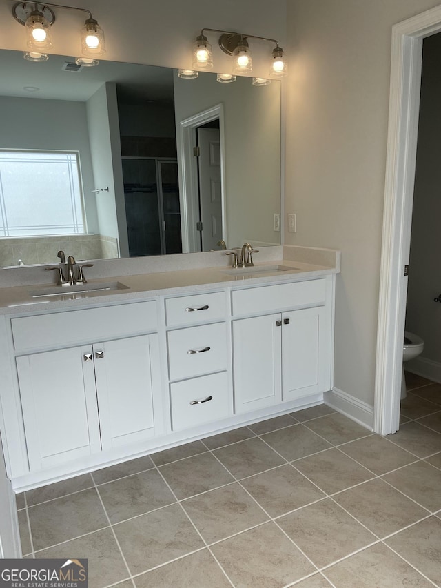 bathroom with tile patterned floors, vanity, toilet, and walk in shower