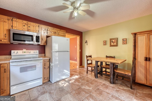 kitchen featuring a textured ceiling, ceiling fan, and white appliances