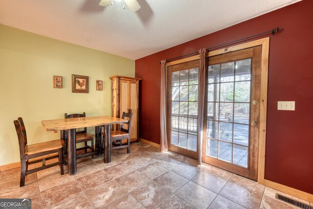 tiled dining area with a textured ceiling and ceiling fan