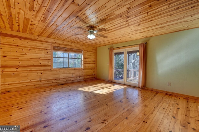 empty room with ceiling fan, light wood-type flooring, and wood ceiling