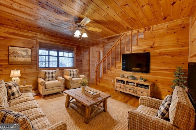 living room with wood walls, ceiling fan, wooden ceiling, and light hardwood / wood-style floors