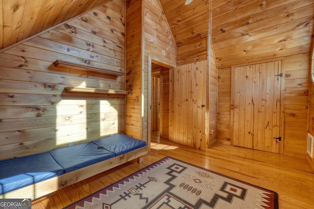 interior space featuring hardwood / wood-style flooring, high vaulted ceiling, wooden walls, and wood ceiling