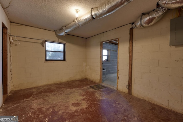 basement featuring electric panel and a textured ceiling