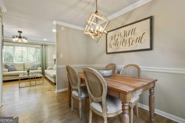 dining space with hardwood / wood-style flooring, a notable chandelier, and crown molding