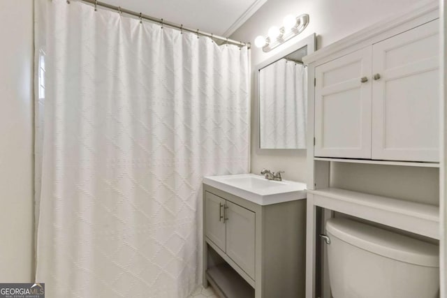 bathroom featuring vanity, toilet, and ornamental molding