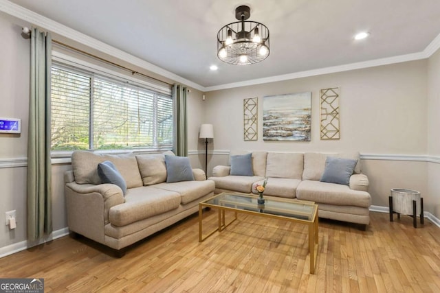 living room featuring an inviting chandelier, light hardwood / wood-style flooring, and ornamental molding