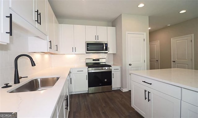 kitchen featuring white cabinets, sink, decorative backsplash, light stone counters, and stainless steel appliances