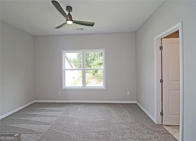 empty room featuring ceiling fan and light colored carpet