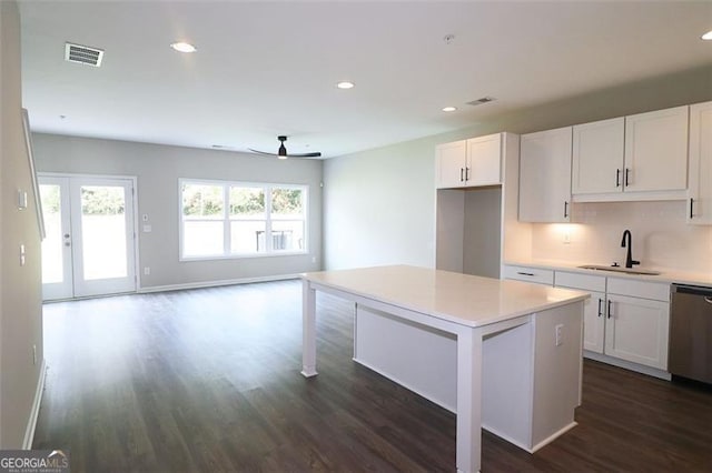 kitchen featuring a center island, sink, stainless steel dishwasher, dark hardwood / wood-style flooring, and white cabinetry