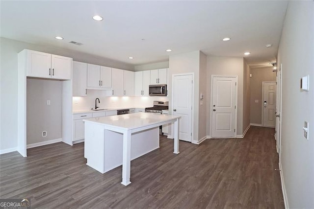 kitchen with a breakfast bar, a center island, white cabinetry, and stainless steel appliances