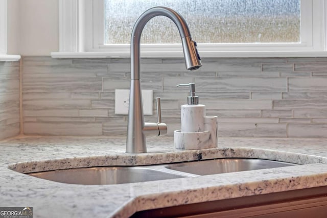 interior details featuring light stone counters and sink