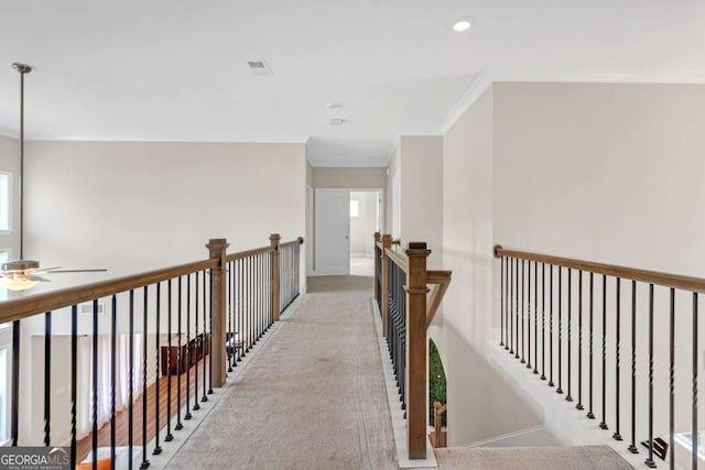 hallway with plenty of natural light and ornamental molding