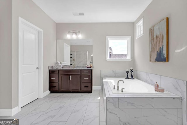 bathroom featuring vanity and tiled bath