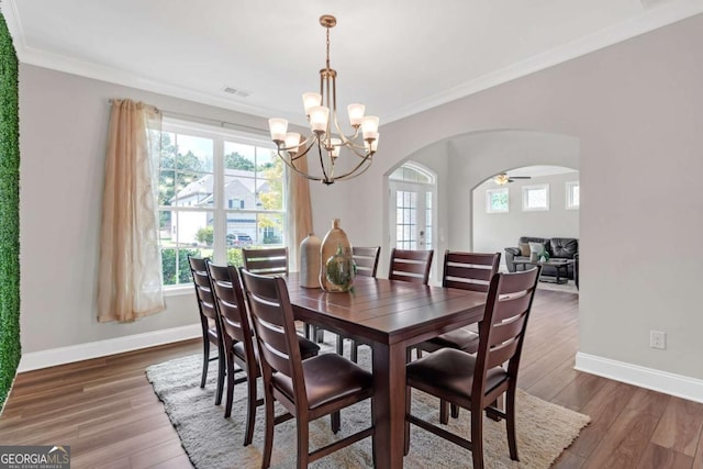 dining space with a healthy amount of sunlight, dark hardwood / wood-style floors, and ornamental molding