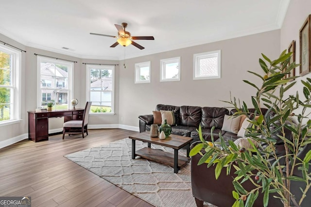 living room with a healthy amount of sunlight, ceiling fan, and crown molding