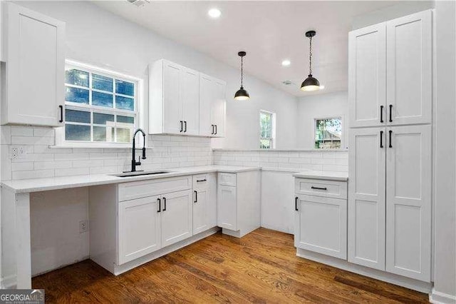 kitchen with dark hardwood / wood-style flooring, white cabinetry, sink, and tasteful backsplash