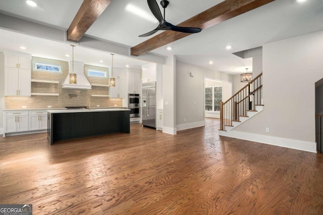 unfurnished living room with dark hardwood / wood-style flooring, ceiling fan, and beamed ceiling