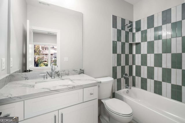 full bathroom featuring vanity, toilet, and tiled shower / bath combo