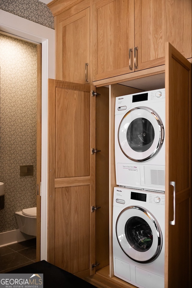 washroom featuring tile patterned flooring and stacked washing maching and dryer