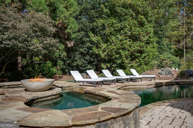 view of pool featuring a patio area and a hot tub