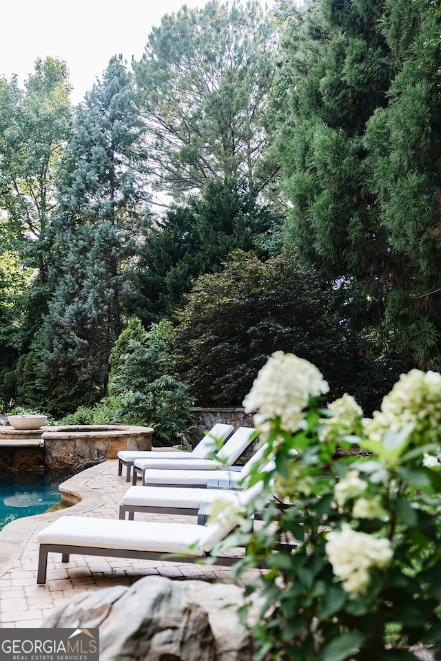 view of home's community with a swimming pool and a patio