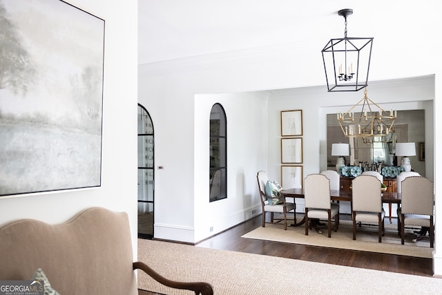 dining area with ornamental molding, dark hardwood / wood-style floors, and a notable chandelier