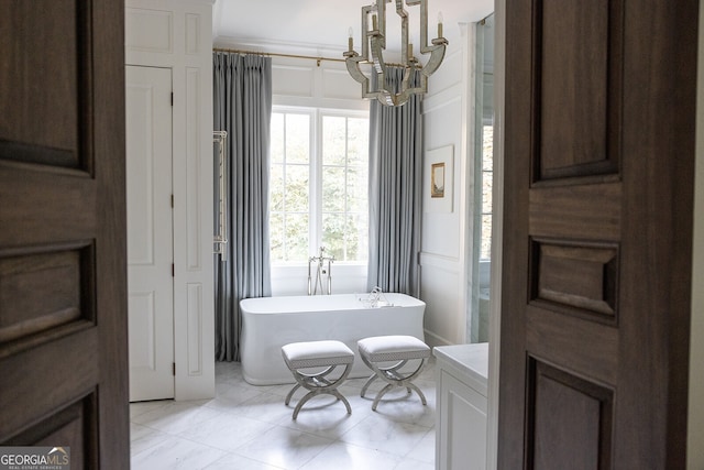 bathroom featuring vanity, a tub, crown molding, and an inviting chandelier