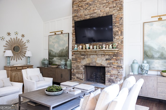 living room with lofted ceiling, dark wood-type flooring, and a fireplace