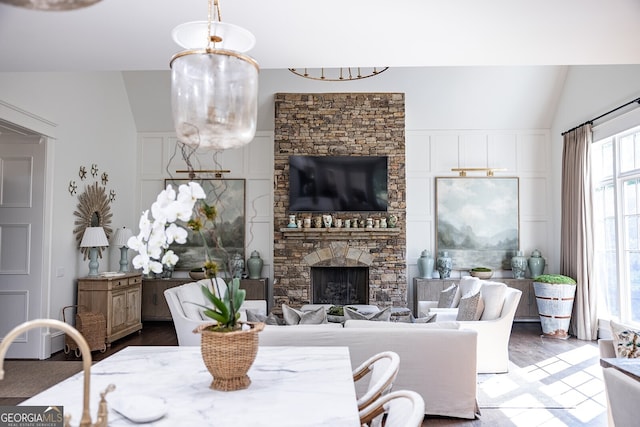 dining room with hardwood / wood-style flooring, lofted ceiling, and a fireplace