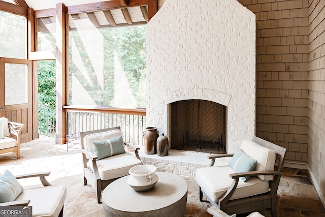 interior space with an outdoor brick fireplace and beam ceiling