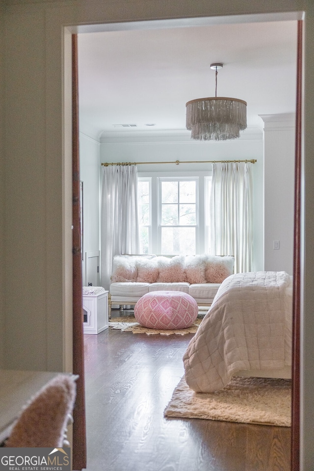 bedroom with an inviting chandelier, crown molding, and dark wood-type flooring