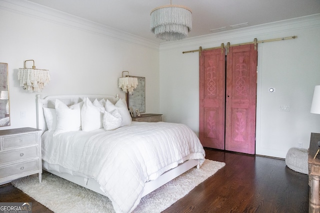 bedroom with dark hardwood / wood-style floors, ornamental molding, and a barn door