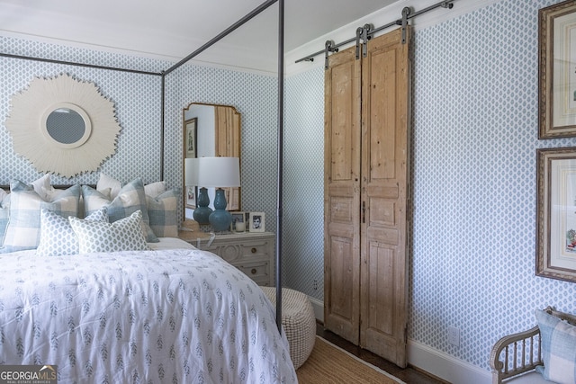 bedroom with crown molding and a barn door