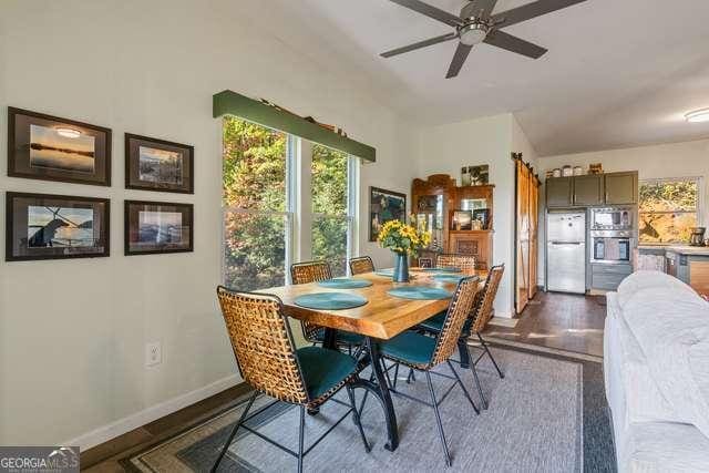 dining room with ceiling fan and dark wood-type flooring