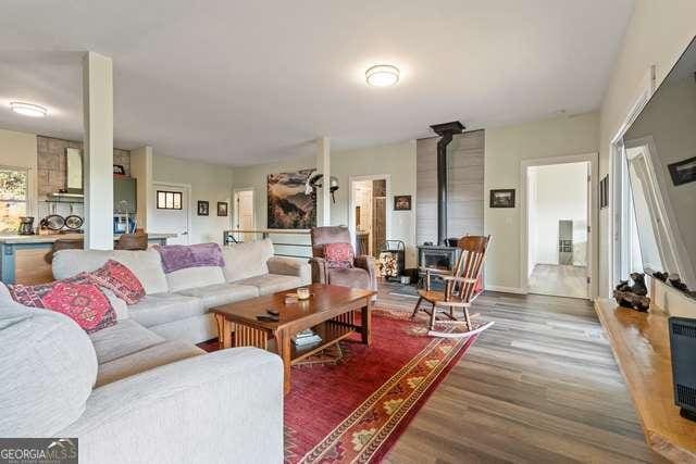 living room with hardwood / wood-style floors and a wood stove