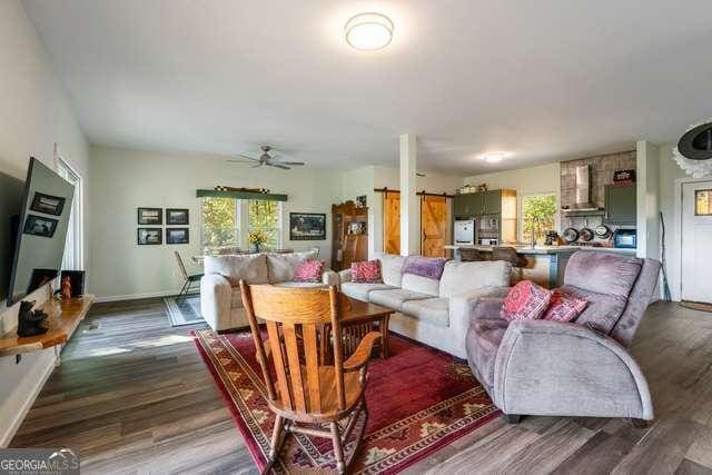 living room with hardwood / wood-style flooring and ceiling fan