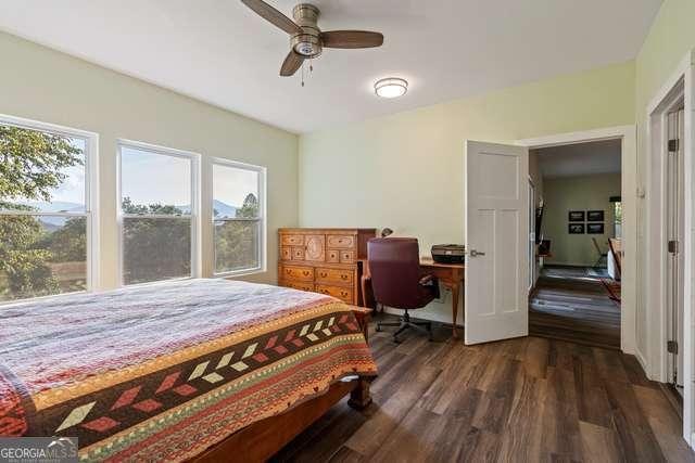 bedroom with dark hardwood / wood-style floors and ceiling fan