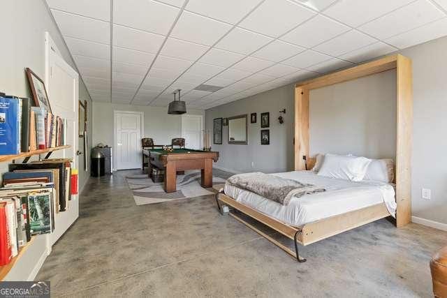 bedroom featuring concrete floors and billiards