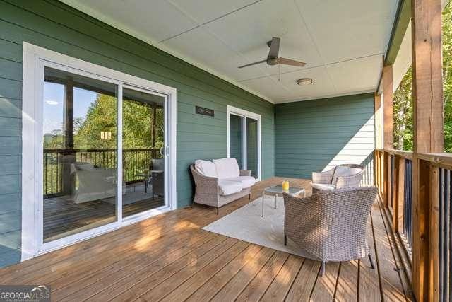 wooden terrace with an outdoor living space and ceiling fan